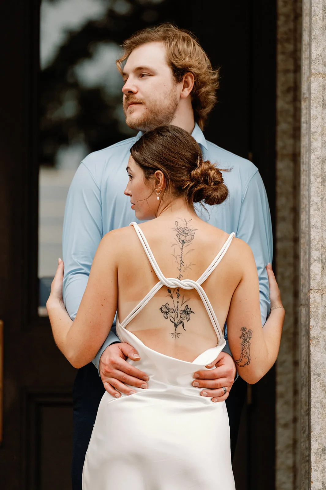Abby and Jake embracing in a doorway on their wedding day
