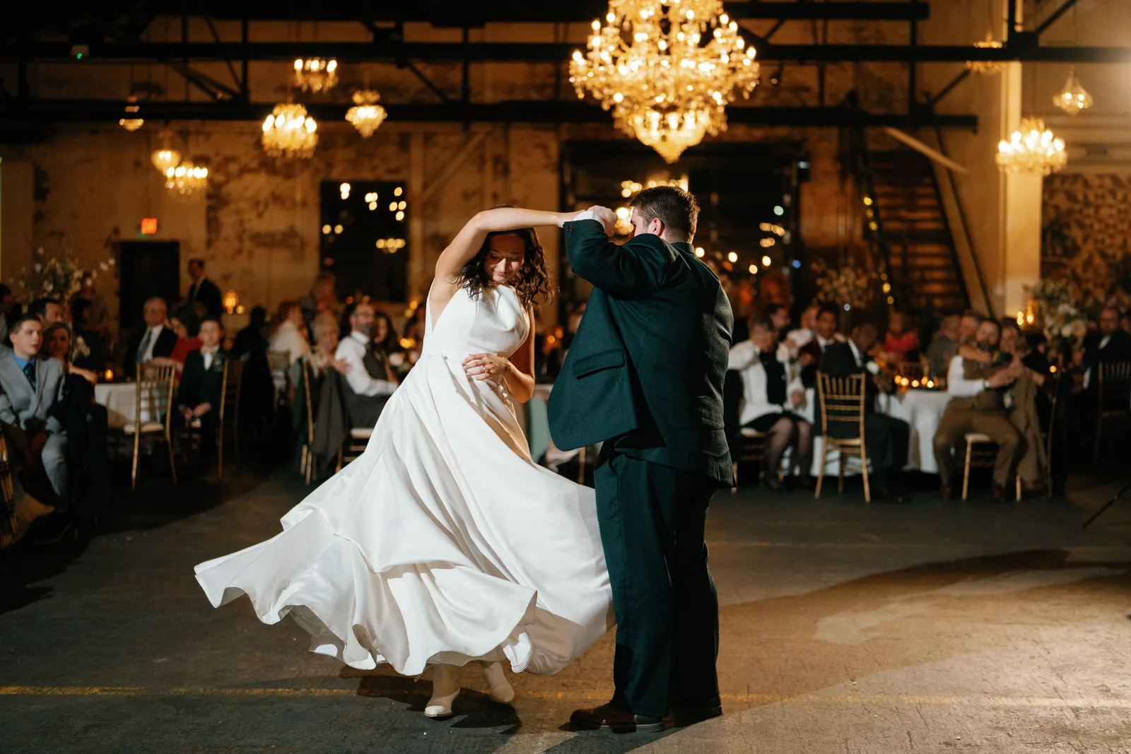 Bella twirling in her gown during the first dance under chandeliers